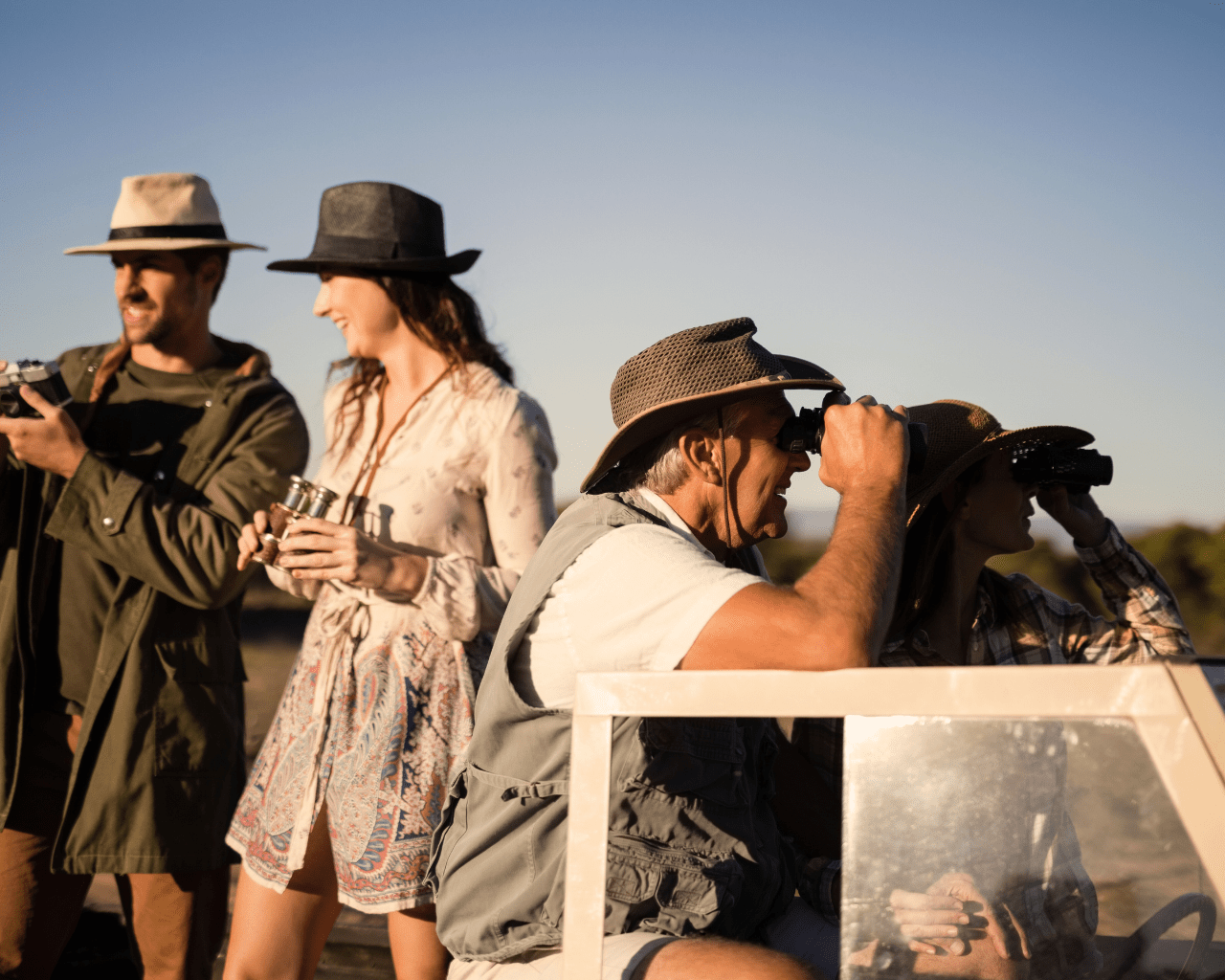 Sustainable Safaris Africa - Journeys - Luxury Madikwe Family Safari Thumbnail - Couple Taking Picture with Camera and Elderly Couple with Binoculars